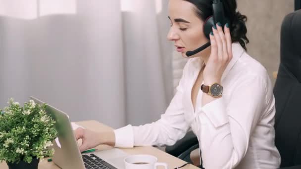 Mujer joven que lleva a cabo consultas en línea mientras está en el cargo — Vídeos de Stock