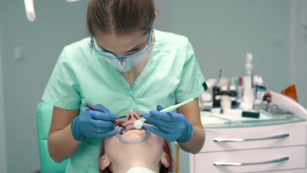 Mujer joven dentista mientras trabaja en la clínica — Vídeo de stock