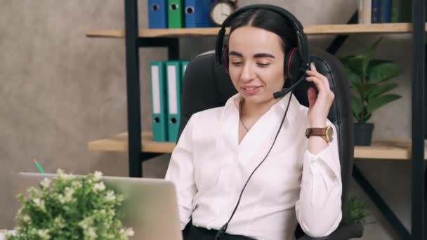 Female call center worker answers customer call in office — Stock Video