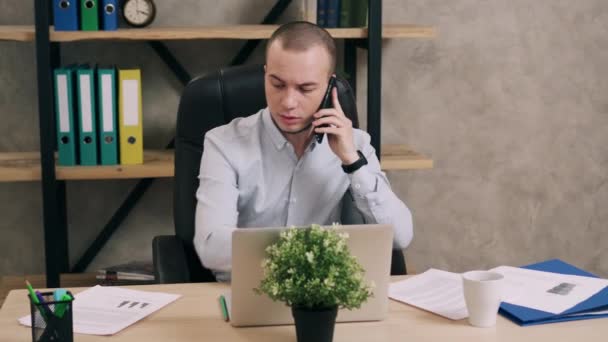 Young man talking on phone in office — Stock Video
