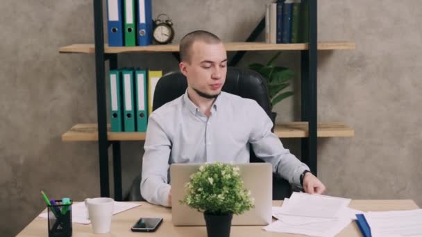 Ung man göra pappersarbete i office — Stockvideo