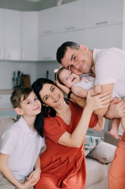 Mutlu bir aile evdeki koltukta oturuyor.