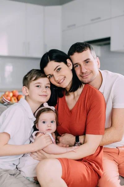 Familia feliz sentada en el sofá en casa —  Fotos de Stock