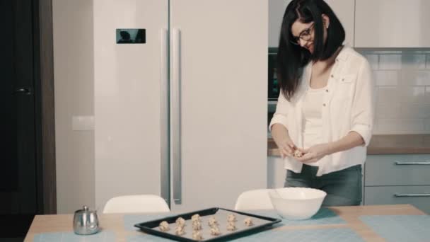 Jovem mulher fazendo biscoitos caseiros na cozinha — Vídeo de Stock