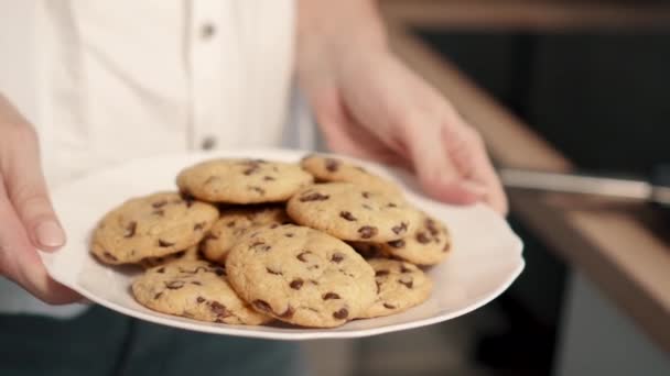 Kvinna som håller plattan med färska kakor i köket — Stockvideo