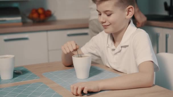 Niño bebiendo té con su padre en la cocina — Vídeo de stock