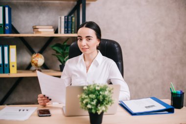 Genç kadın ofiste kamera bakıyor