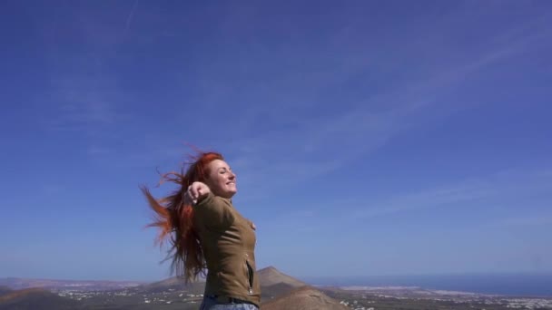 Женщина турист любуется видом с вершины горы — стоковое видео