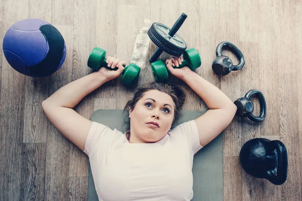 Fáradt kövér nő feküdt a padlón az edzőteremben — Stock Fotó