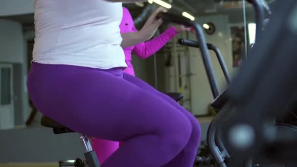 Fat woman sits tired on stationary bike — Stock Video