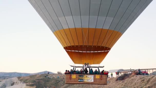 Goreme, Turkije-1 november, 2018: toeristen vliegen hete ballon over rotsen — Stockvideo