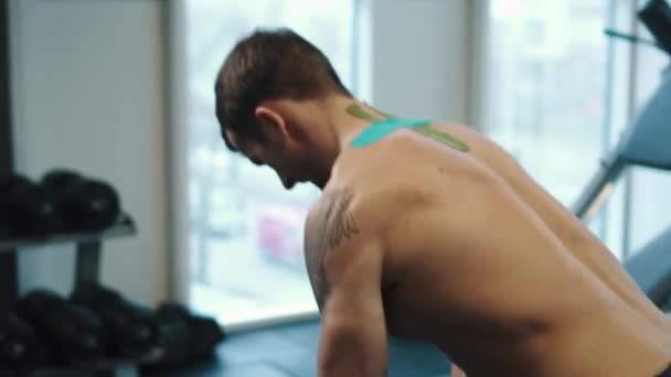 Мускулистый человек занимается кроссфитом в спортивном холдинге — стоковое видео