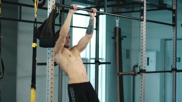 Стронгмэн тренирует мышцы живота в баре в тренажерном зале — стоковое видео
