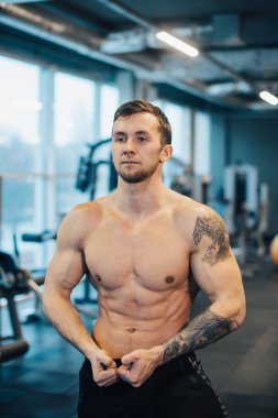 Spor salonunda çıplak gövdesi olan genç bir sporcu.