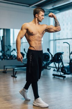 Spor salonunda çıplak gövdesi olan genç bir sporcu.