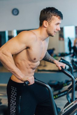 Genç adam giymek eğitim neredeyse üzerinde bisiklet makine