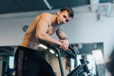 Atletik adam bisiklet makinesi üzerinde egzersiz sonrası dinlenme