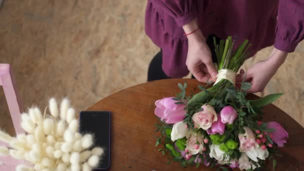 Primer plano de las manos femeninas atadas en cinta de lazo en ramo — Vídeos de Stock