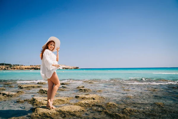 Woman tourist white dress standing on beach with crystal clear water. — Stock Photo, Image