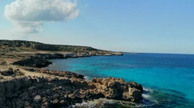 Güneşli bir günde Cape Cavo Greco yakınlarında hava manzaralı mavi göl