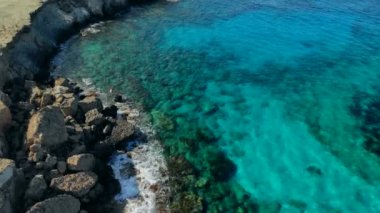 Güneşli bir günde Cape Cavo Greco yakınlarında hava manzaralı mavi göl