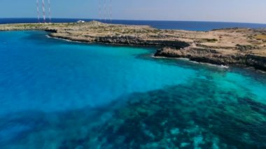 Güneşli bir günde Cape Cavo Greco yakınlarında hava manzaralı mavi göl
