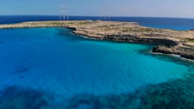 Güneşli bir günde Cape Cavo Greco yakınlarında hava manzaralı mavi göl