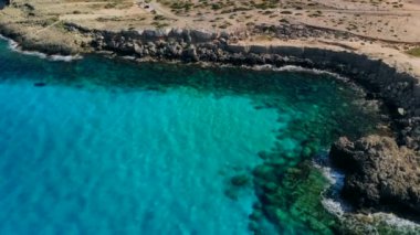 Güneşli bir günde Cape Cavo Greco yakınlarında hava manzaralı mavi göl