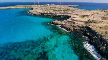 Güneşli bir günde Cape Cavo Greco yakınlarında hava manzaralı mavi göl