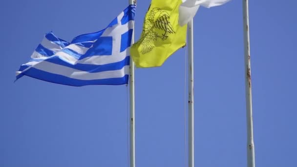 Fahnen Zyperns und Griechenlands flattern im Wind gegen blauen Himmel — Stockvideo