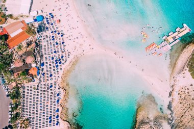 Akdeniz 'de güneşli bir günde bir sürü turistin olduğu güzel bir sahil.