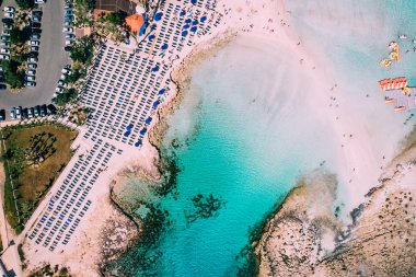 Akdeniz 'de güneşli bir günde bir sürü turistin olduğu güzel bir sahil.