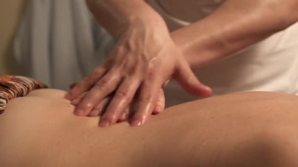 Close-up of male masseur hands massaging back of woman in spa salon — Stock Video