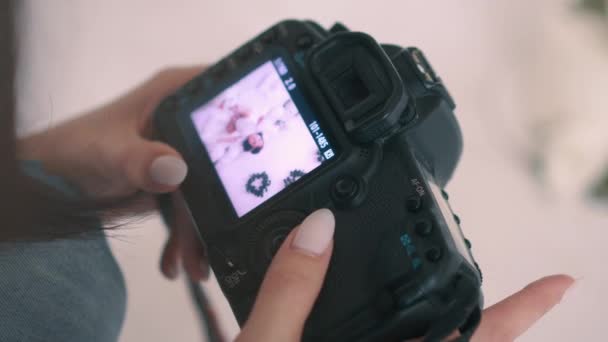 Fotógrafo mira imágenes de la cámara en pantalla capturadas durante la sesión de fotos de los niños, primer plano detallado — Vídeo de stock