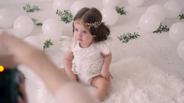 Female photographer takes pictures of little baby in photo studio. — Stock Video