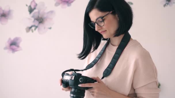 Молода жінка-фотограф дивиться на камеру і посміхається — стокове відео
