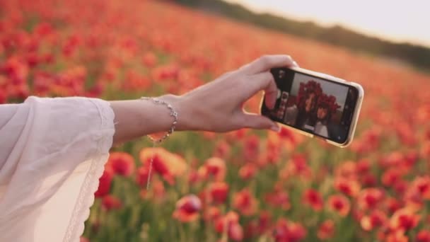 Anne ve kızı kırmızı Poppies çiçeklenme alanında akıllı telefon kullanarak selfie almak, yakın çekim, yavaş hareket — Stok video
