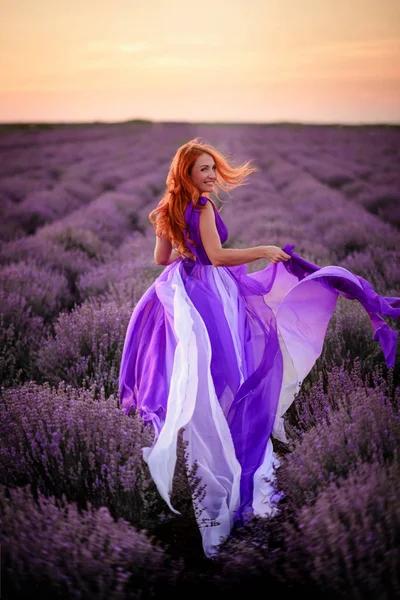 ラベンダー畑に立つ豪華な紫色のドレスの若い女性、リアビュー — ストック写真