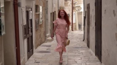 Mutlu genç kadın turist eski Avrupa şehrinin sokaklarında yürüyüş, yavaş hareket