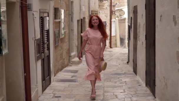 Happy young woman tourist walking through streets of old European city, slow motion — Stock Video
