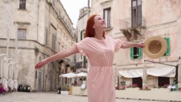 Mutlu kadın turist gülüyor ve eski Avrupa şehir sokakta fırtınası. — Stok video