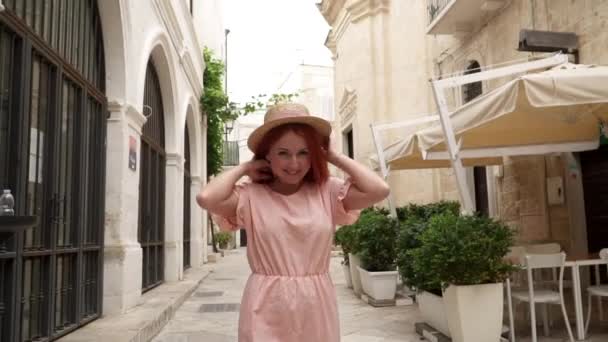 Happy young woman tourist walking through streets of old European city, slow motion — Stock Video