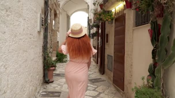 Mujer joven paseos turísticos por las calles de la ciudad vieja en Italia, vista trasera — Vídeo de stock