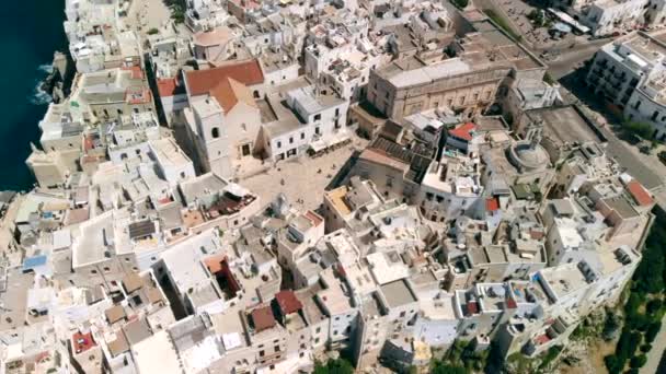 Gün batımında İtalya'nın Polignano şehrinin çatıları ve plajı üzerinde uçmak, Apulia — Stok video