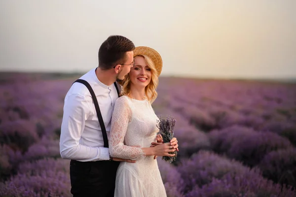 Çiçekli lavanta alanında genç mutlu gelin ve damat sarılmak — Stok fotoğraf