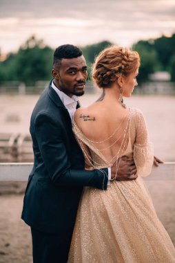 İki aşık erkek ve kadın gün batımında bir çiftlikte kucaklayan standı