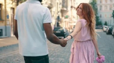 Genç mutlu kadın şehir sokak boyunca erkek arkadaşları el yol açar, arka görünümü