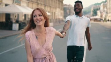 Genç mutlu kadın şehir sokak boyunca erkek arkadaşları el yol açar