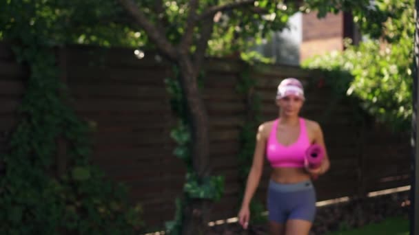 Mulher atlética jovem vem para o treino com tapete de fitness, câmera lenta — Vídeo de Stock