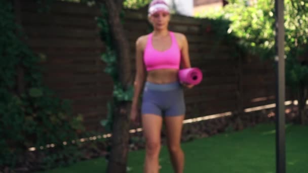 Jonge atletische vrouw komt om te trainen met fitness mat, close-up buik — Stockvideo